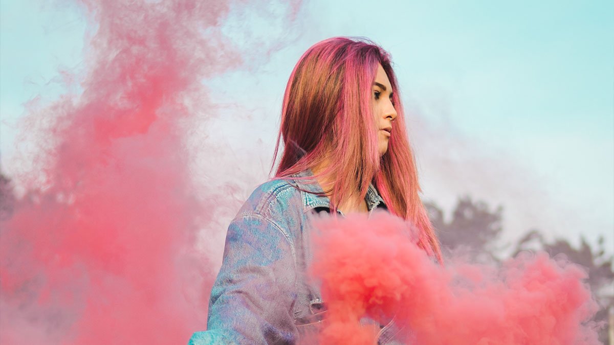 Woman wearing a blue on leather by pink smoke